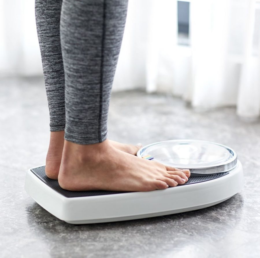 A woman checking her weight on a scale